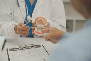 Dentists are discussing dental problems at report x-ray image on laptop screen to patients. photo