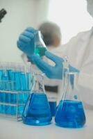 Health care researchers working in life science laboratory. Young female research scientist and senior male supervisor preparing and analyzing microscope slides in research lab. photo