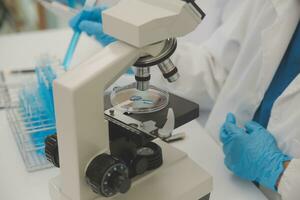 Health care researchers working in life science laboratory. Young female research scientist and senior male supervisor preparing and analyzing microscope slides in research lab. photo