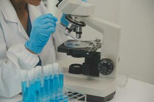 Health care researchers working in life science laboratory. Young female research scientist and senior male supervisor preparing and analyzing microscope slides in research lab. photo