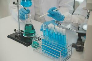 Health care researchers working in life science laboratory. Young female research scientist and senior male supervisor preparing and analyzing microscope slides in research lab. photo