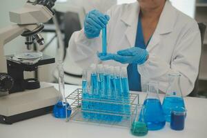 Health care researchers working in life science laboratory. Young female research scientist and senior male supervisor preparing and analyzing microscope slides in research lab. photo
