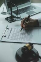 Business and lawyers discussing contract papers with brass scale on desk in office. Law, legal services, advice, justice and law concept picture with film grain effect photo