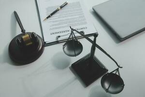 Business and lawyers discussing contract papers with brass scale on desk in office. Law, legal services, advice, justice and law concept picture with film grain effect photo