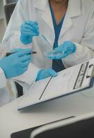 Health care researchers working in life science laboratory. Young female research scientist and senior male supervisor preparing and analyzing microscope slides in research lab. photo