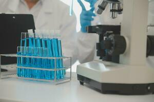 Health care researchers working in life science laboratory. Young female research scientist and senior male supervisor preparing and analyzing microscope slides in research lab. photo