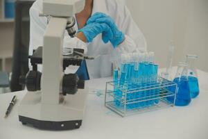 Health care researchers working in life science laboratory. Young female research scientist and senior male supervisor preparing and analyzing microscope slides in research lab. photo
