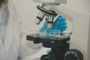 Health care researchers working in life science laboratory. Young female research scientist and senior male supervisor preparing and analyzing microscope slides in research lab. photo