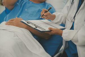 Close up of Female Doctor using stethoscope putting beat heart diagnose with patient in examination room at a hospital, check-up body, Medical and Health Care Concept. photo