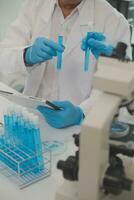 Health care researchers working in life science laboratory. Young female research scientist and senior male supervisor preparing and analyzing microscope slides in research lab. photo