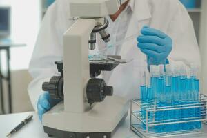 Health care researchers working in life science laboratory. Young female research scientist and senior male supervisor preparing and analyzing microscope slides in research lab. photo