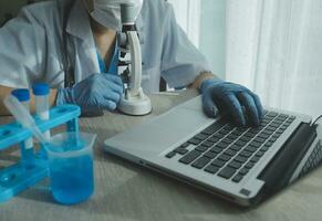 Young scientists conducting research investigations in a medical laboratory, a researcher in the foreground is using a microscope photo