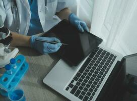 Young scientists conducting research investigations in a medical laboratory, a researcher in the foreground is using a microscope photo