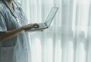 Doctor working with laptop computer in medical workspace office. doctor working on laptop computer in modern clinics office. search medical information. banner copy space photo