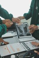 multirracial equipo de doctores que se discute un paciente en pie agrupado en el vestíbulo mirando a un tableta computadora, cerca arriba ver foto