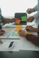 Close up ux developer and ui designer brainstorming about mobile app interface wireframe design on table with customer breif and color code at modern office.Creative digital development agency photo