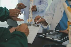 Group of doctors reading a document in meeting room at hospital photo