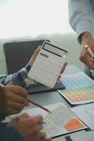 Close up ux developer and ui designer brainstorming about mobile app interface wireframe design on table with customer breif and color code at modern office.Creative digital development agency photo