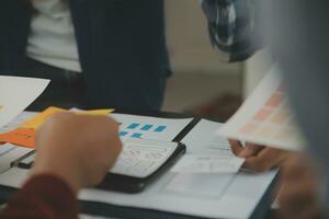 Close up ux developer and ui designer brainstorming about mobile app interface wireframe design on table with customer breif and color code at modern office.Creative digital development agency photo