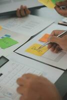 Close up ux developer and ui designer brainstorming about mobile app interface wireframe design on table with customer breif and color code at modern office.Creative digital development agency photo