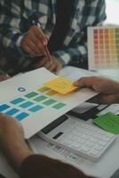 Close up ux developer and ui designer brainstorming about mobile app interface wireframe design on table with customer breif and color code at modern office.Creative digital development agency photo