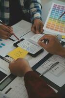 Close up ux developer and ui designer brainstorming about mobile app interface wireframe design on table with customer breif and color code at modern office.Creative digital development agency photo