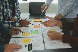 Close up ux developer and ui designer brainstorming about mobile app interface wireframe design on table with customer breif and color code at modern office.Creative digital development agency photo