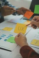 Close up ux developer and ui designer brainstorming about mobile app interface wireframe design on table with customer breif and color code at modern office.Creative digital development agency photo