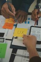 Close up ux developer and ui designer brainstorming about mobile app interface wireframe design on table with customer breif and color code at modern office.Creative digital development agency photo