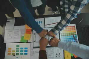 Close up ux developer and ui designer brainstorming about mobile app interface wireframe design on table with customer breif and color code at modern office.Creative digital development agency photo