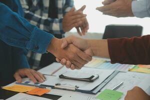 Close up ux developer and ui designer brainstorming about mobile app interface wireframe design on table with customer breif and color code at modern office.Creative digital development agency photo