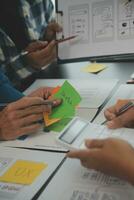 Close up ux developer and ui designer brainstorming about mobile app interface wireframe design on table with customer breif and color code at modern office.Creative digital development agency photo