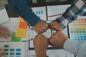 Close up ux developer and ui designer brainstorming about mobile app interface wireframe design on table with customer breif and color code at modern office.Creative digital development agency photo
