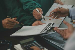 Group of doctors reading a document in meeting room at hospital photo