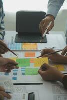 Close up ux developer and ui designer brainstorming about mobile app interface wireframe design on table with customer breif and color code at modern office.Creative digital development agency photo