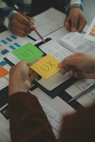 Close up ux developer and ui designer brainstorming about mobile app interface wireframe design on table with customer breif and color code at modern office.Creative digital development agency photo