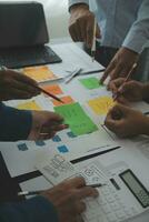 Close up ux developer and ui designer brainstorming about mobile app interface wireframe design on table with customer breif and color code at modern office.Creative digital development agency photo