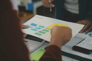 Close up ux developer and ui designer brainstorming about mobile app interface wireframe design on table with customer breif and color code at modern office.Creative digital development agency photo
