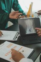 Group of doctors reading a document in meeting room at hospital photo