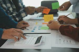 Close up ux developer and ui designer brainstorming about mobile app interface wireframe design on table with customer breif and color code at modern office.Creative digital development agency photo
