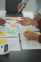 Close up ux developer and ui designer brainstorming about mobile app interface wireframe design on table with customer breif and color code at modern office.Creative digital development agency photo