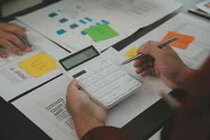 Close up ux developer and ui designer brainstorming about mobile app interface wireframe design on table with customer breif and color code at modern office.Creative digital development agency photo