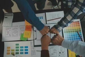 Close up ux developer and ui designer brainstorming about mobile app interface wireframe design on table with customer breif and color code at modern office.Creative digital development agency photo