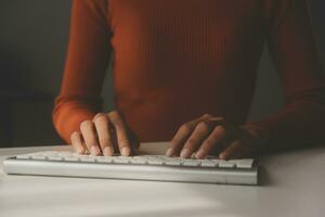 Asian Businesswoman Using laptop computer and working at office with calculator document on desk, doing planning analyzing the financial report, business plan investment, finance analysis concept. photo