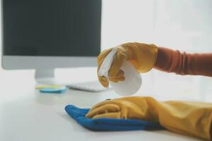 Office Cleaning Service. Janitor Spraying Desk. Workplace Hygiene photo