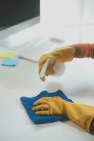 Office Cleaning Service. Janitor Spraying Desk. Workplace Hygiene photo