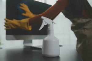 Office Cleaning Service. Janitor Spraying Desk. Workplace Hygiene photo