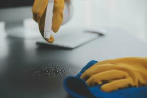 Office Cleaning Service. Janitor Spraying Desk. Workplace Hygiene photo