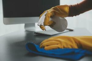 Office Cleaning Service. Janitor Spraying Desk. Workplace Hygiene photo