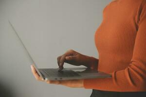 Asian Businesswoman Using laptop computer and working at office with calculator document on desk, doing planning analyzing the financial report, business plan investment, finance analysis concept. photo